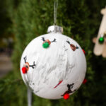 white round ornament decorated with mini reindeer faces